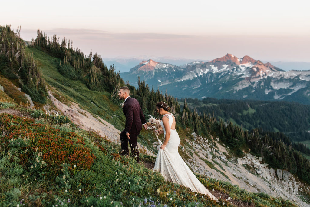 Newly eloped couple walking through wildflowers at Mount Rainier