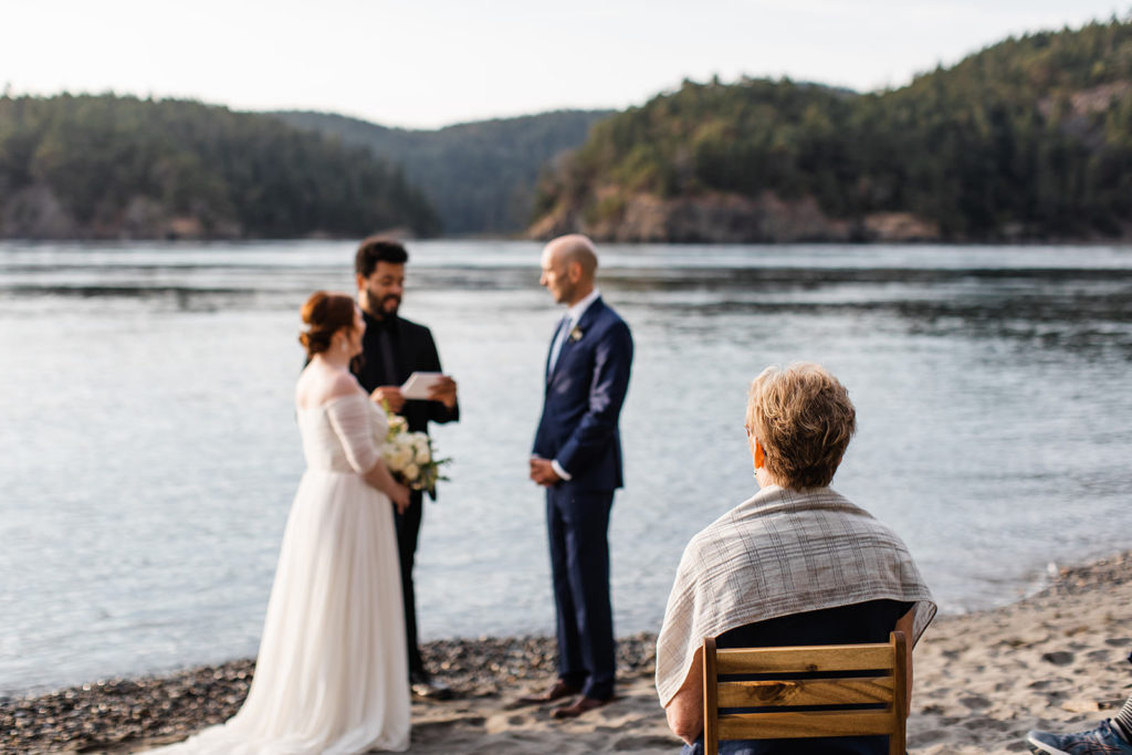 Family watching an elopement ceremony in front of a lake