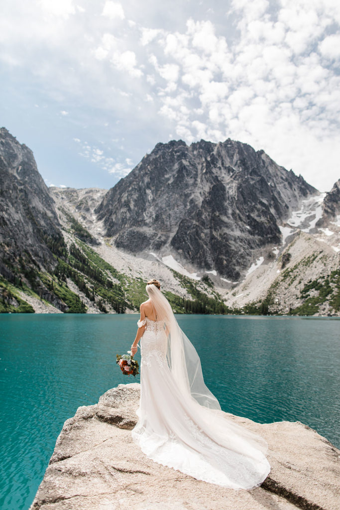 Bride standing on a rock lookout out at Lake Colchuck