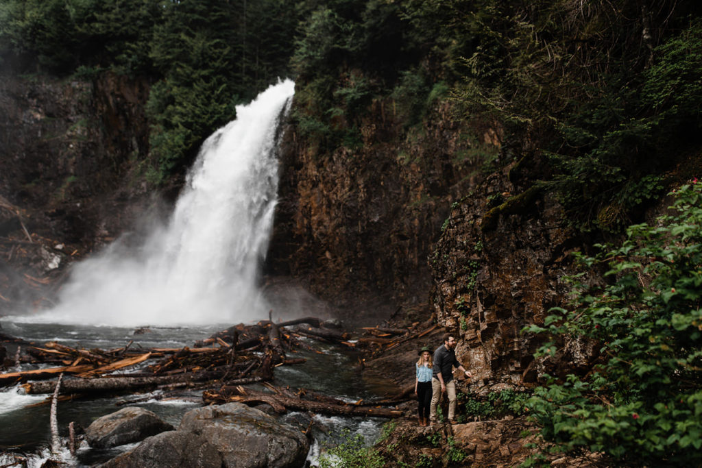 Engaged couple walking away from Franklin Falls during their engagement photos