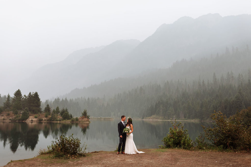 Newly married bride and groom facing each other after their elopement at Gold Creek Pond during forest fire season