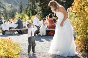A bride looking down at her ring bearer during the reception after her elopement at Bagley Lakes in the Mount Baker area