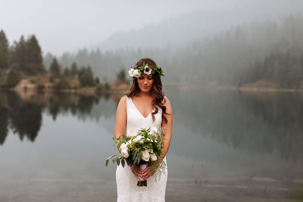 Bride with a flower crown holding her boho-themed bouquet for her intimate wedding at Gold Creek Pond in Washington State