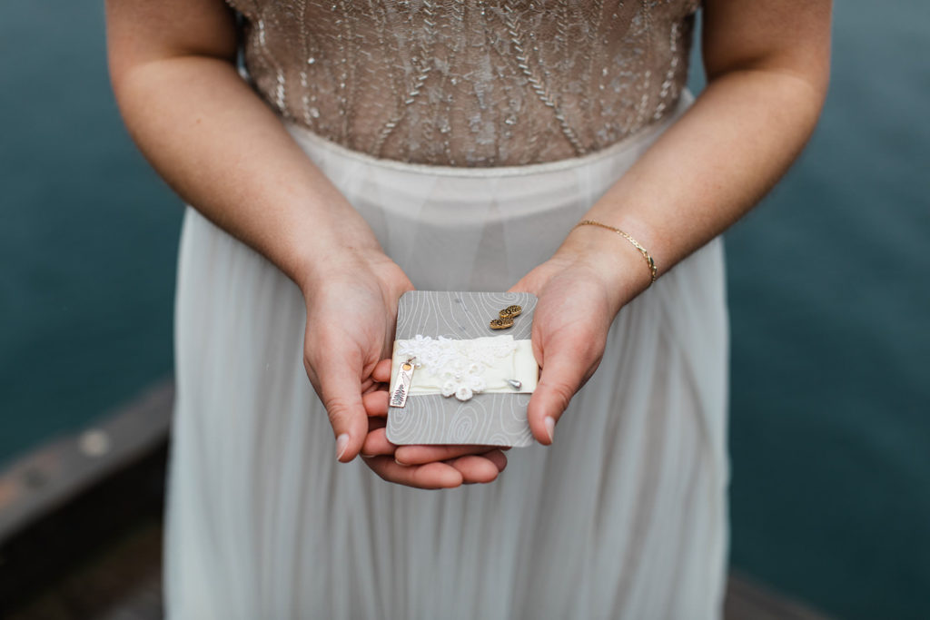 A bride holding a few keepsakes from deceased relatives on her wedding day at Lake Crescent in Washington