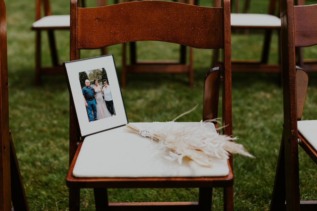 A framed photo of a deceased loved one placed on an empty chair during a wedding at The Finery in Washington