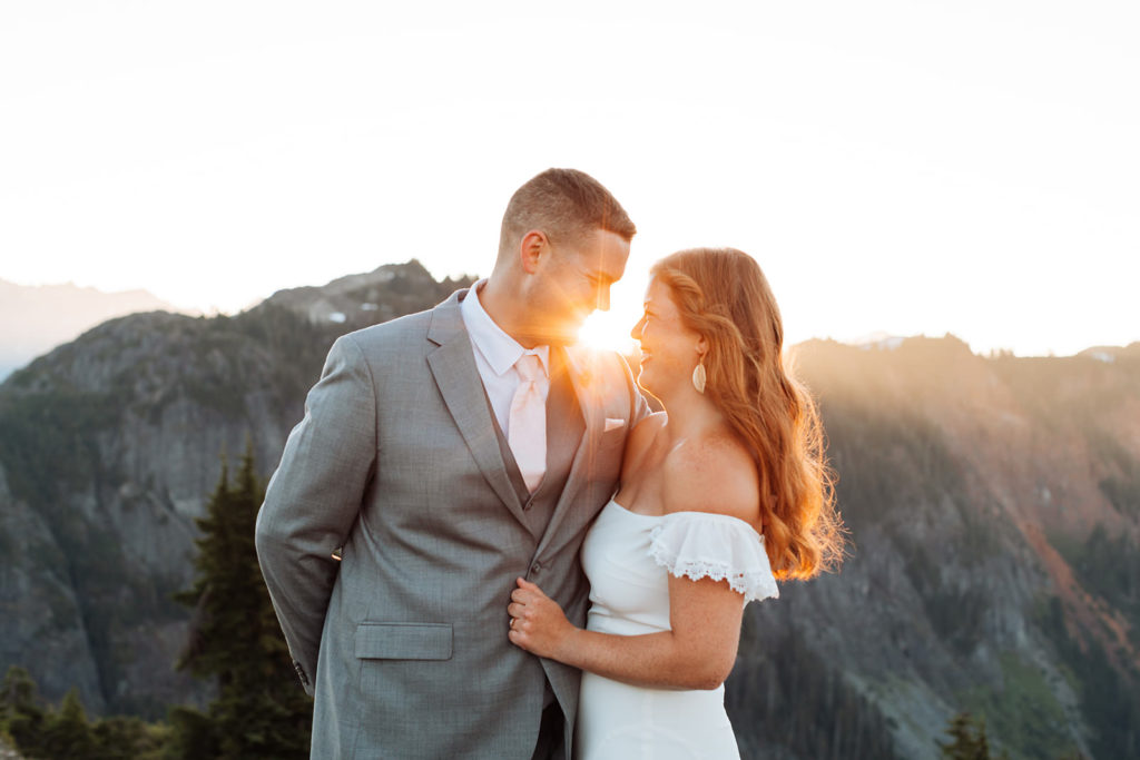 Newlyweds embracing in front of sunset at the Snoqualmie National Forest